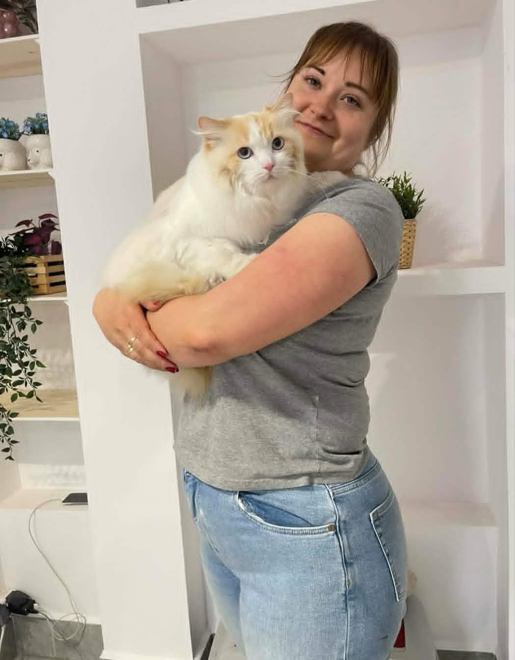 Portret groomerki z kotem na rękach